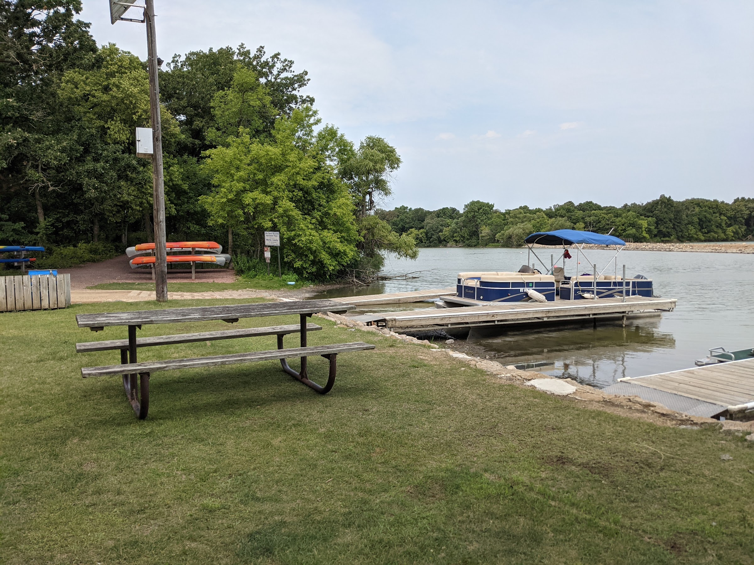 boat docks and boat in the foreground, lake and causeway in the background