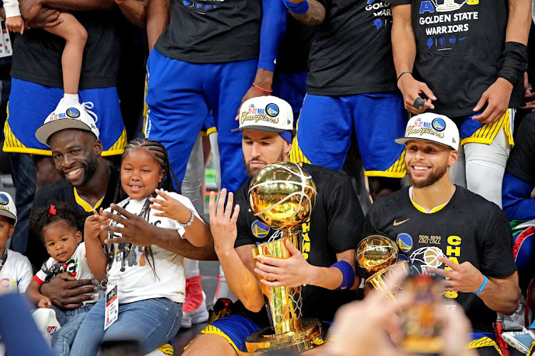 Golden State Warriors forward Draymond Green (23), guard Klay Thompson (11) and guard Stephen Curry (30) celebrate after beating the Boston Celtics in game six of the 2022 NBA Finals to win the NBA Championship at TD Garden.