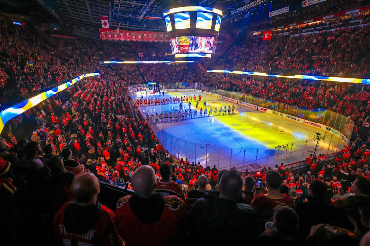 Ukrainian flags are displayed during Ukraine national anthem performed by Stephania Romaniuk prior to the game between the Calgary Flames and the Edmonton Oilers at Scotiabank Saddledome.