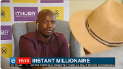 eNCA journalist Lindokuhle Xulu chats to the winner of the R232m PowerBall in Johannesburg on Tuesday. The winner, wearing a hat with his back to the camera, didn't want to be identified.