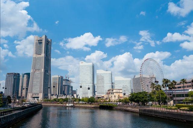 マンションなどの大きな建物と、川が流れる都会の風景