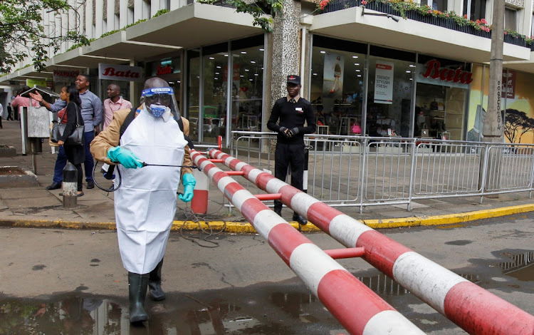 A worker sprays disinfectant on a security barrier outside a hotel to prevent the spread of Covid-19 coronavirus along the streets in downtown Nairobi, Kenya. On Thursday the country confirmed its first death related to Covid-19.