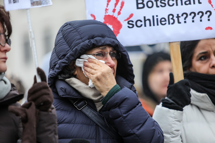 A participant cries as people protest in solidarity with the ongoing demonstrations in Iran and against the Islamic Republic's regime in front of the Brandenburg Gate on December 10 2022 in Berlin, Germany.