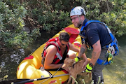 Safely back on the ground with his rescuers.