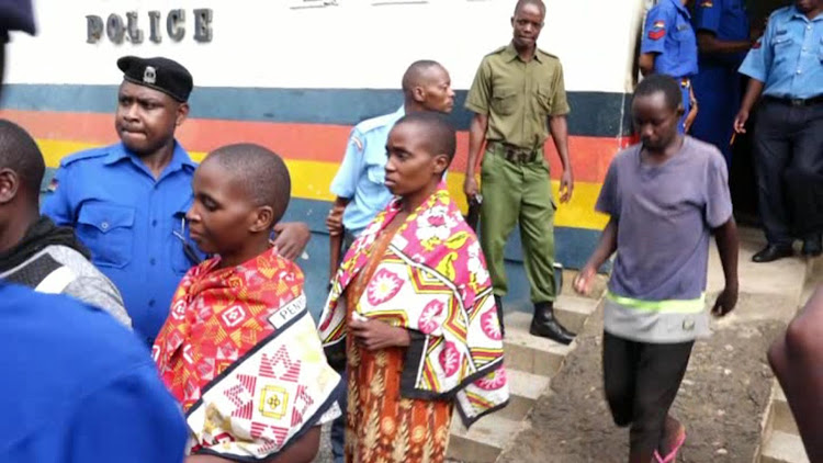 Followers of the controversial preacher Paul Mackenzie being escorted to a police Landcruiser from Malindi Police station to the Malindi law courts.