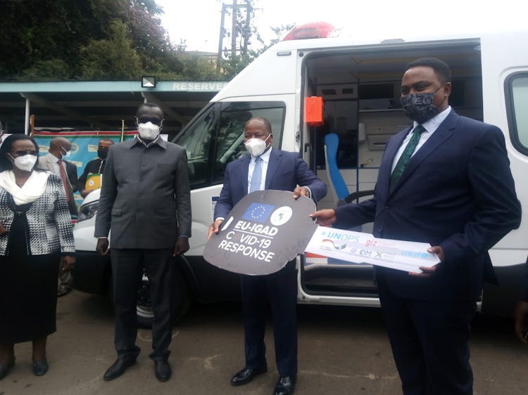 Turkana Governor Nanok, Health CS Kagwe and Igad executive secretary Workneh Gebeyehu hand over ambulance to Turkana county at Afya House on July 28.