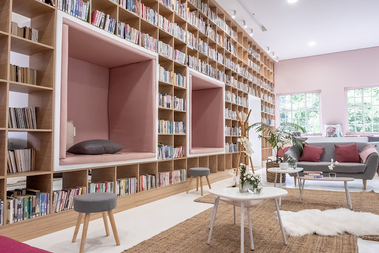 The new bookshelf acts as a divider, sectioning off the more chilled side of the library from the classroom and computer side behind it. Cosy reading nooks have been recessed into the shelf.