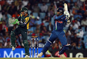 CENTURION, SOUTH AFRICA:  Kamran Akmal watches as  Raul Dravid of India hits out during The ICC Champions Trophy match between India and Pakistan.