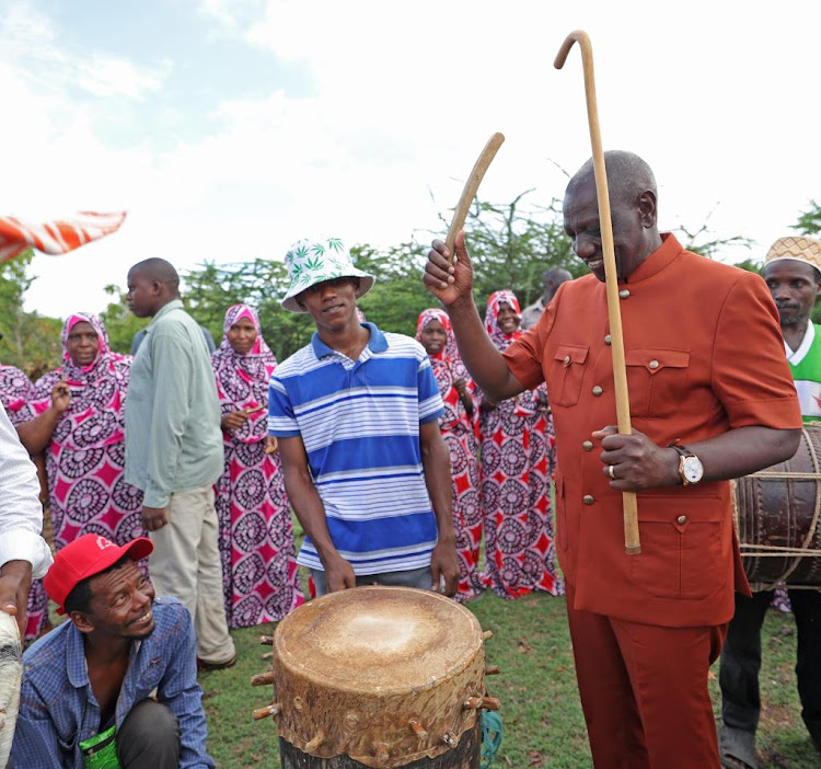 President William Ruto beats a drum during the opening of the Lamu East Technical and Vocational College on November 4, 2023.