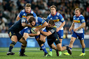 Frans Malherbe of the Western Stormers is tackled by Otago Highlanders' Malakai Fekitoa (front L) and Dillon Hunt (front R) during the Super Rugby match between the Otago Highlanders of New Zealand and the Western Stormers of South Africa at Forsyth Barr Stadium in Dunedin on April 28, 2017.