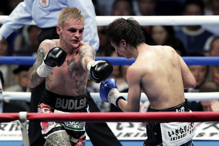 Challenger Hekkie Budler (L) of South Africa punches champion Ryoichi Taguchi of Japan during the IBF & WBA Light Flyweight Title Bout at Ota City General Gymnasium on May 20, 2018 in Tokyo, Japan.