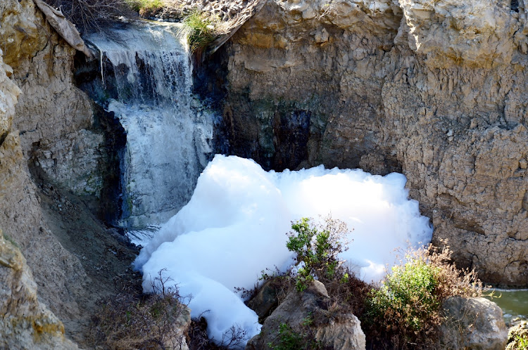 Markman stormwater canal in full flow on Wednesday, filled with foul-smelling effluent on its way down to the Swartkops Estuary. The foam is generated because of chemicals and toxins in the flow