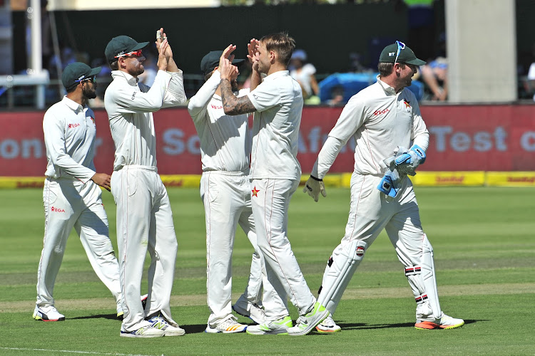 Graeme Cremer Captain of Zimbabwe comes in to congratulate bowler Kyle Jarvis of Zimbabwe for dismissing Dean Elgar of the Proteas during day 1 of the 2017 day-night Sunfoil Test match between South Africa and Zimbabwe at St Georges Park, Port Elizabeth on 26 December 2017.