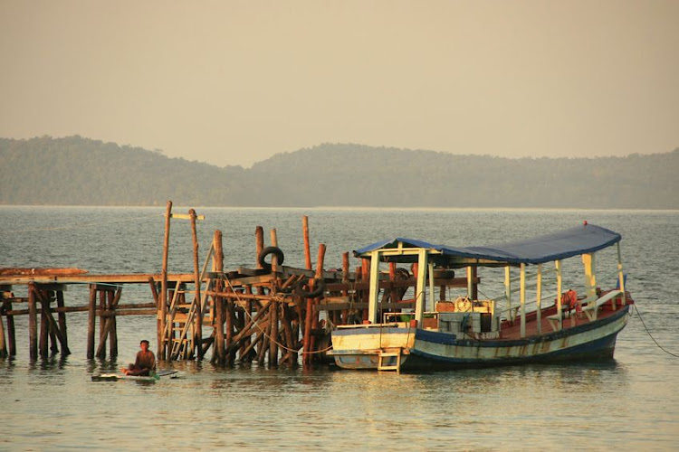 Wooden jetty and fishing boat on Koh Rong Samloem island, Cambodia.