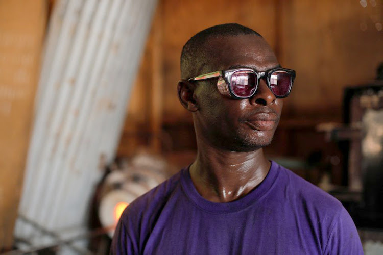 Ghanaian glassblower Michael Tetteh, 44, looks on while working at his glassware manufacturing workshop in Krobo Odumase, Ghana March 15, 2022.