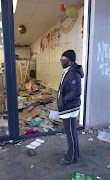 Thandi Johnson stands in front of her destroyed shop.