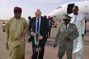 Kassoum Mocta (L), Niger Minister of Sport, and Colonel Djibrilla Hamidou, President of Niger Football Federation (R), receive FIFA President Gianni Infantino in Niamey on February 27, 2017.