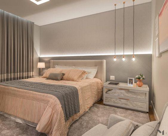 Quarto de casal com decoração e tons neutros cinza e rose, luminárias pendentes, piso de madeira