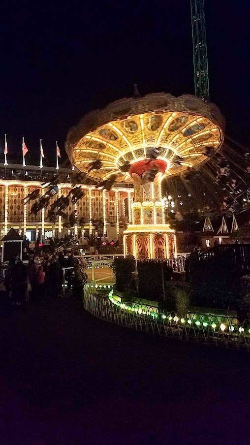 The Star Flyer is the high swing carousel ride in the back right, and the the Swing Carousel to the left from 1907 used at Halloween and Christmas / Visiting Tivoli Amusement park during Halloween decoration time, October 2018