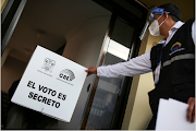 A National Electoral Council (CNE) member holds electoral material as part of a program for people with disabilities to vote ahead of the second round in country's presidential election, in Quito, Ecuador on April 9 2021. 