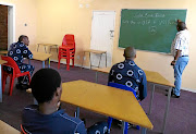 Learners at Usethubeni School, a prison learning centre  for young offenders, do revision with their teacher./CHRIS MAKHAYE