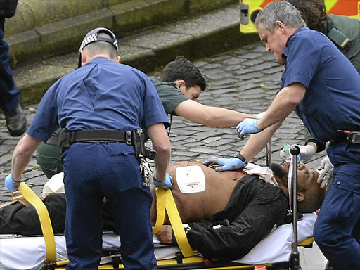 Emergency services attend to Khalid Masood, who was shot and killed by police outside the Palace of Westminster in London after he ploughed his car into pedestrians and stabbed a policeman.