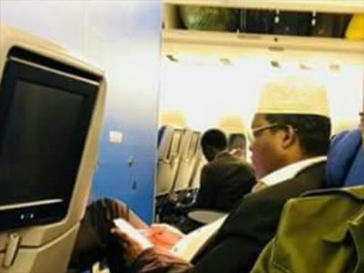 Miguna Miguna(seated second) inside a plane at JKIA. He was deported to Canada on Tuesday night. COURTESY