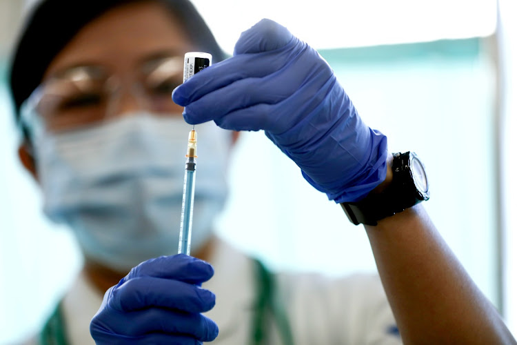 A medical worker fills a syringe with a dose of the Pfizer-BioNTech coronavirus disease (Covid-19) vaccine, at Tokyo Medical Centre