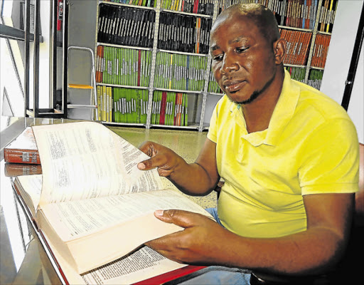 OH MY WORD: Zola Wababa, director of the University of Fort Hare IsiXhosa National Lexicography Unit, pages through his unit’s definitive Greater Dictionary of IsiXhosa Picture: MIKE LOEWE