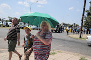 Members of the community pass an ANC protest outside the school.