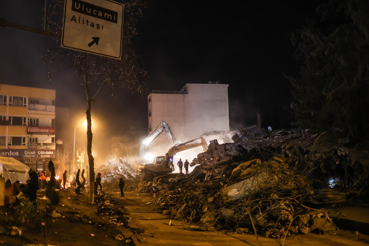 Heavy machinery being used to clear mounds of debris from fallen buildings in the city of Adıyaman in Türkiye