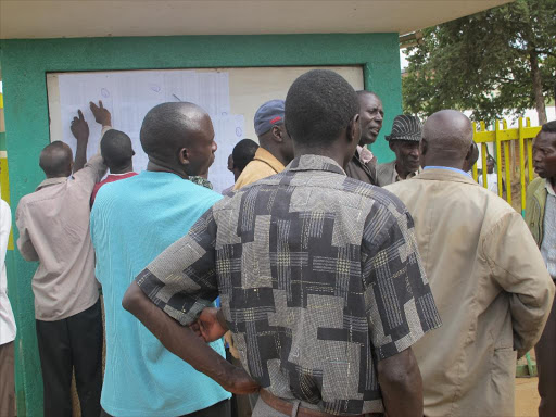 Farmers who have paid for the fertiliser looking for their names at Cereals notice board in Kitale./PHOTO/NICHOLAS WAMALWA.