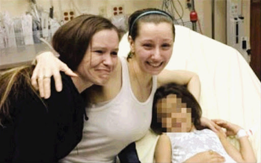 Amber Berry, centre, is reunited with her sister at a Cleveland, Ohio, hospital after she, a girl believed to be her daughter, and two other women, Gina DeJesus and Michelle Knight, were freed from a house in which they had been held captive for a decade