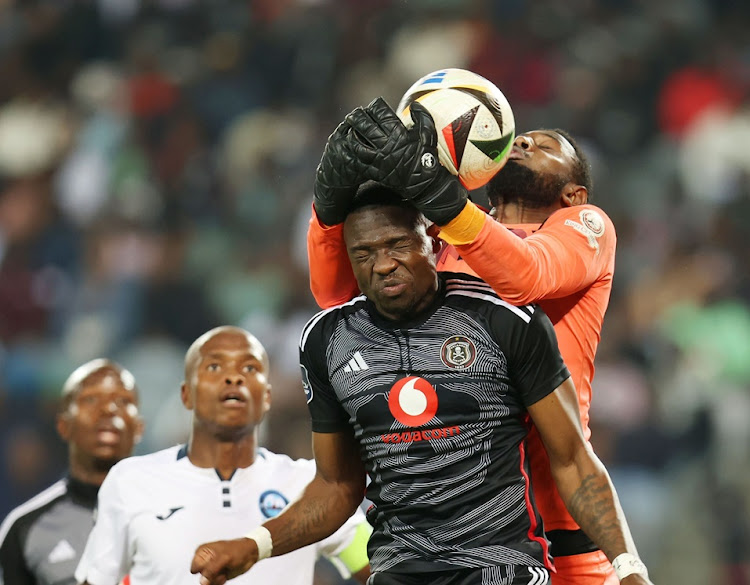 Tshegofatso Mabasa of Orlando Pirates goes up for the ball wit Richards Bay goalkeeper Salim Magoola in the DStv Premiership match at Orlando Stadium on Saturday night.