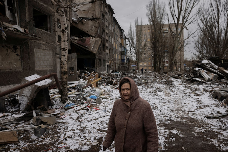 A woman walks past apartment blocks that were destroyed in a Russian missile strike in Selydove near Avdiivka, Ukraine, February 19 2024. Picture: THOMAS PETER/REUTERS