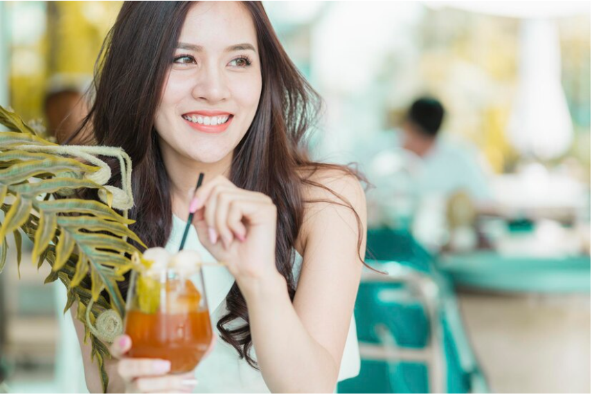 Seorang wanita terlihat senang karena tengah menikmati minuman berbahan madu