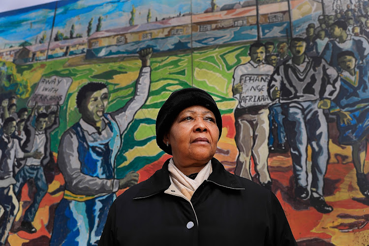 Antionette Sithole, the sister of Hector Pieterson, in front of a wall at Memorial Acre.