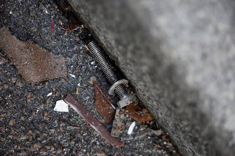 A bolt lies on the ground after the sails of the red windmill atop the Moulin Rouge fell off during the night on April 25 2024.