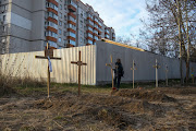 A man stands next to graves with bodies of civilians, who according to local residents were killed by Russian soldiers, in Bucha, in Kyiv region on April 4 2022.