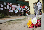 A bouquet of flowers in the foreground mark the spot where Emaan Solomon's family members found her body after she was shot on Tuesday.