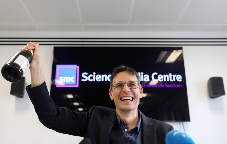 Swiss scientist Didier Queloz celebrates with a champagne at a news conference, following the announcement he wins the 2019 Nobel Prize for Physics, in London, on Tuesday, October 8, 2019.