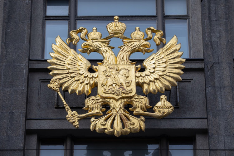 The coat of arms of the Russian Federation is shown on the front of the Duma building in Moscow, Russia, February 22 2022. Picture: BLOOMBERG/ANDREY RUDAKOV
