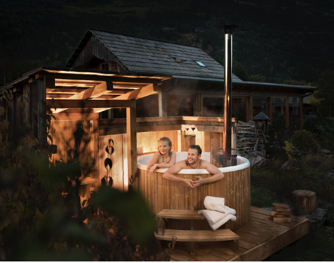 A wood-fired hot tub from Skargards on a wooden deck base.