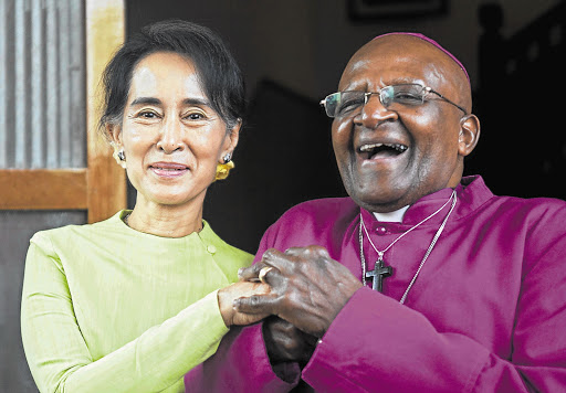 Burma democracy icon Aung San Suu Kyi and retired Archbishop Desmond Tutu in front of Suu Kyi's house after a meeting of the two Nobel Peace Prize winners in Yangon, Burma, yesterday