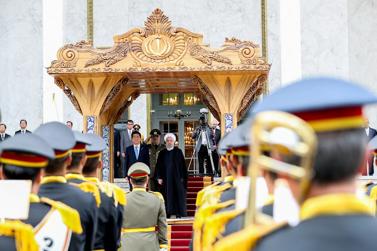 Iranian President Hassan Rouhani stands with Japan's Prime Minister Shinzo Abe, during a welcome ceremony in Tehran, Iran, on June 12 2019.