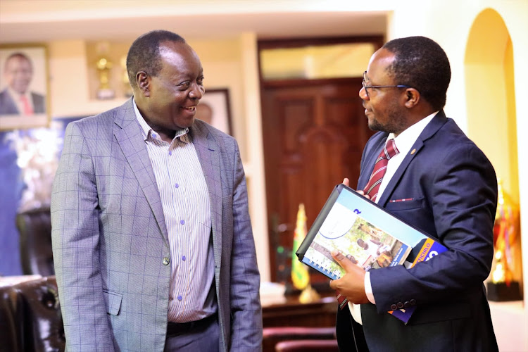 Governor Wilber Ottichilo with David Oluoch Director of Partnerships, Advocacy and Communication from Living Goods Kenya organization while at Vihiga governor's office on Tuesday.