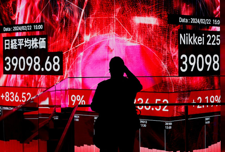 A visitor takes photos of an electronic screen displaying Japan’s Nikkei share average in Tokyo, Japan, February 22 2024. Picture: REUTERS/ISSEI KATO