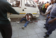 An injured man beaten in a  mob   justice  incident- after The Red Ants evicted illegal tenants from a building on the corner of Jeppe and Nugget Street in Johannesburg. Pic: Alon Skuy. 16/10/2007. © The Times.