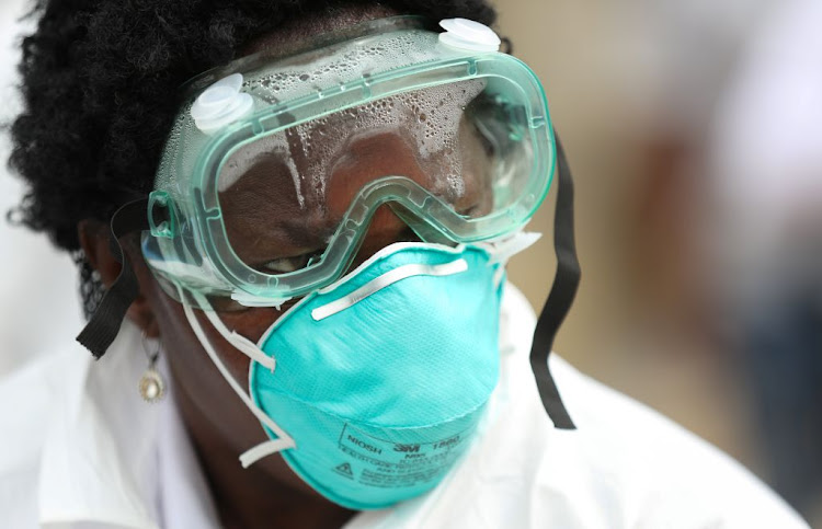 A medical staff member tests residents in Alexandra to try contain the coronavirus outbreak in South Africa, on March 31 2020.