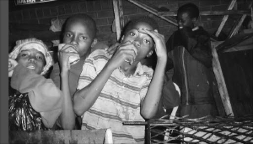 HOMELESS PLIGHT: Street children in the Durban city centre at night sniffing what appeared to be glue. Pic: ELIJAR MUSHIANA. 17/03/2004. © Sowetan.